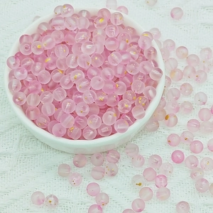 Macro detail of 6mm frosted pink glass beads with gold foil inside for DIY jewelry