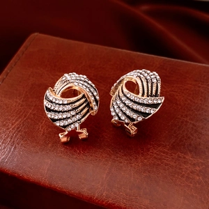 Close-up of vintage gold wing earrings with rhinestones and black enamel on leather