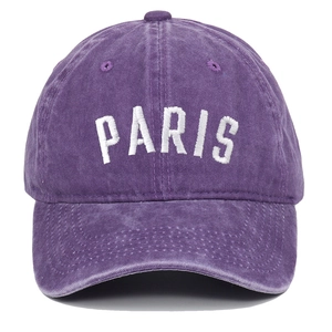 Detailed view of white PARIS embroidery on vintage washed purple cotton baseball cap