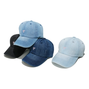 Denim baseball caps with pink bow embroidery in four washed shades on white background
