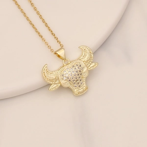 Macro shot of gold bull head pendant with micro-pave zircons on a ceramic plate