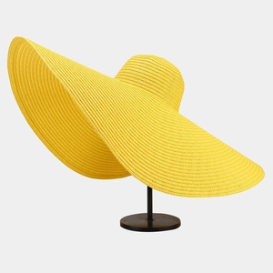 Detail of wide brim straw hat in vibrant yellow featuring intricate woven texture and sun shield