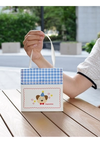 Close-up of blue checkered gift box with cartoon dog and smooth white ribbon handle