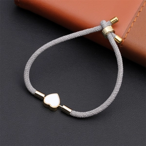 Detail of adjustable gray Milan rope bracelet with a gold-edged white heart charm