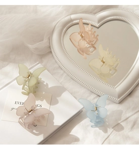 Detailed close-up of matte acrylic butterfly hair claws in pastel Macaron colors