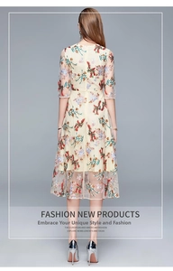 Detailed close-up of intricate multi-color floral embroidery on beige tulle dress
