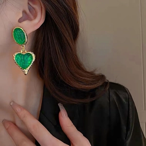Vintage style gold earrings with green oval and heart charms and hammered metal texture