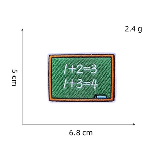 Macro detail of blackboard embroidery patch with chalk formulas measuring 6.8x5cm