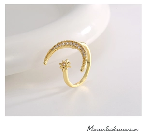 Macro shot of gold star and moon ring featuring micro-inlaid white cubic zirconia details