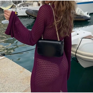 Detalle de vestido largo de punto calado morado con escote en V y mangas acampanadas