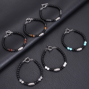 Detailed macro of obsidian and tiger eye stone bead bracelets with metal toggle closures