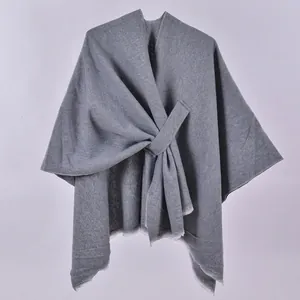 Detailed close-up of dark grey knitted shawl showing fine twill texture and fringed edges