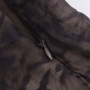 Detailed macro view of the invisible zipper closure on dark camouflage midi skirt fabric