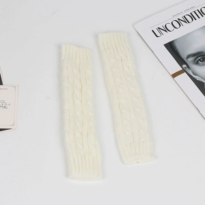Detailed macro view of white cable knit arm warmers with classic twisted texture patterns