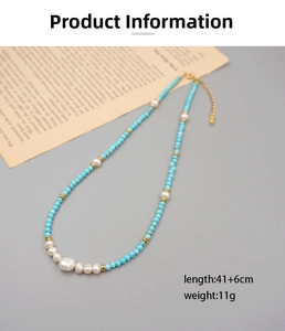 Detail of beaded necklace with turquoise beads and central baroque pearl on grey background