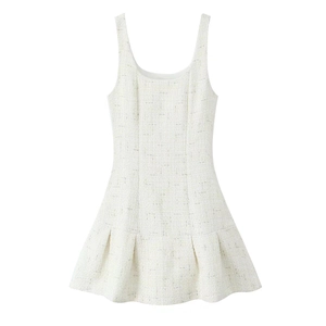 Close-up of white tweed fabric texture and pleated hem on a French style mini dress