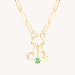 Gold chain necklace with crescent moon, green gemstone and star charms on white background