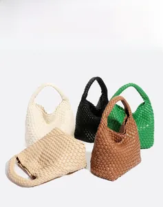 Detail view of woven leather hobo bags in five colors including white, green, and brown