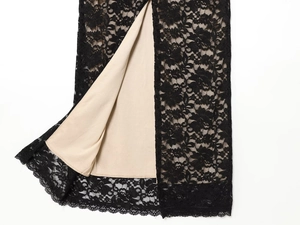 Close-up of black floral lace fabric with beige lining on a backless bodycon dress