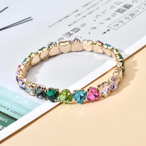 Detailed view of colorful heart-shaped zircon crystals on a gold elastic bracelet