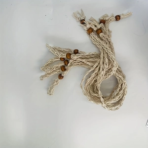 Close-up of bohemian hand-woven cotton cord necklace with dark wooden beads and tassels