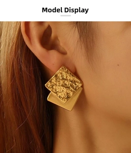 Detail view of gold square earrings with vintage hammered texture on female ear