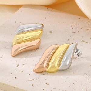 Detailed view of tricolor wave-patterned earrings in gold, silver and rose gold finishes