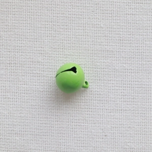 Detail shot of a 14mm bright green painted metal bell with hanging loop on white fabric