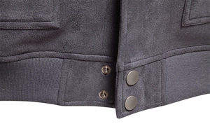 Détail de la veste en suédine gris foncé avec ourlet en tricot côtelé et boutons-pression