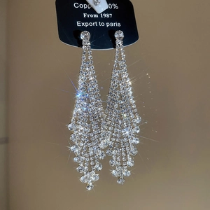 Detail von silbernen Quastenohrringen mit glitzernden Strasssteinen im Luxus Fransen Design