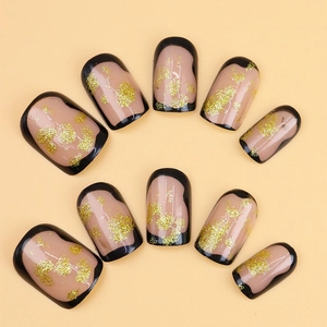 Short square press-on nails with nude base, black French tips and gold glitter accents