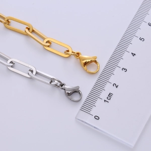 Macro view of 7mm paper clip chain bracelets in gold and silver with lobster clasp