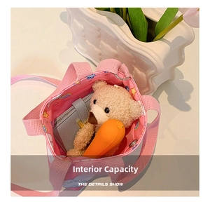 Detail view of pink cartoon canvas bag interior showing capacity for plush toy and wallet