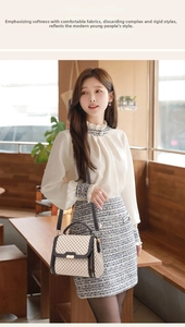 Detailed view of beige diamond pattern handbag with metallic lock and dark trim