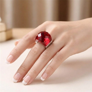 Close-up of a vintage silver ring with a large faceted red crystal on a hand
