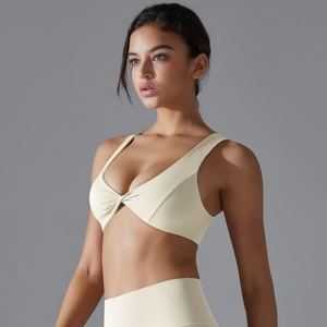 Detail of twist-front nylon sports bra in creamy beige with high elasticity for yoga