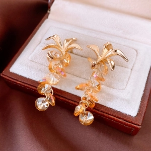 Détail de boucles d'oreilles vintage dorées avec glands en cristal ambré sur velours