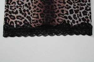 Close-up of leopard print fabric with delicate black lace hem detail on a summer dress