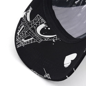 Detailed view of black baseball cap brim with white Eiffel Tower and heart print