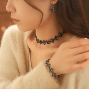 Detail of dark teal beaded jewelry set including necklace, bracelet and earrings for women