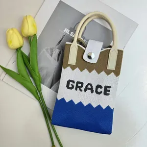 Detail of knit phone bag showing the GRACE lettering and premium magnetic closure