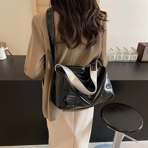 Chic black contrast Boston bag with silver strap detail on a stylish model in blazer