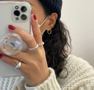 Detailed mirror selfie showing minimalist gold beaded ring and silver logo band