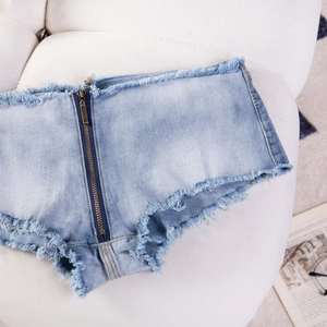 Detail von hellblauen Denim-Shorts mit langem Metallreißverschluss und Fransensäumen