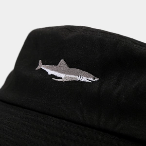 Black cotton bucket hat featuring detailed shark embroidery in a modern fashion style