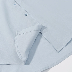 Detailed macro shot of light blue cotton linen shirt hem with split side and fine stitching