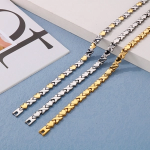 Detailed macro of XOXO magnetic therapy bracelets with heart charms in gold and silver steel