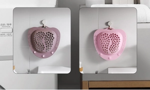 Close-up of pink foot-shaped silicone scrubber with drainage holes and suction cups