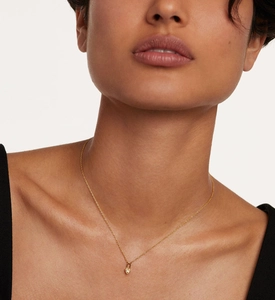 Close-up of a delicate gold heart lock necklace featuring a micro-inset sparkling zircon