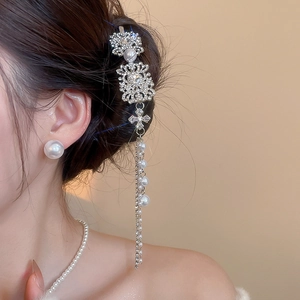 Close-up of vintage hair clip with rhinestones and long dangling pearl tassels
